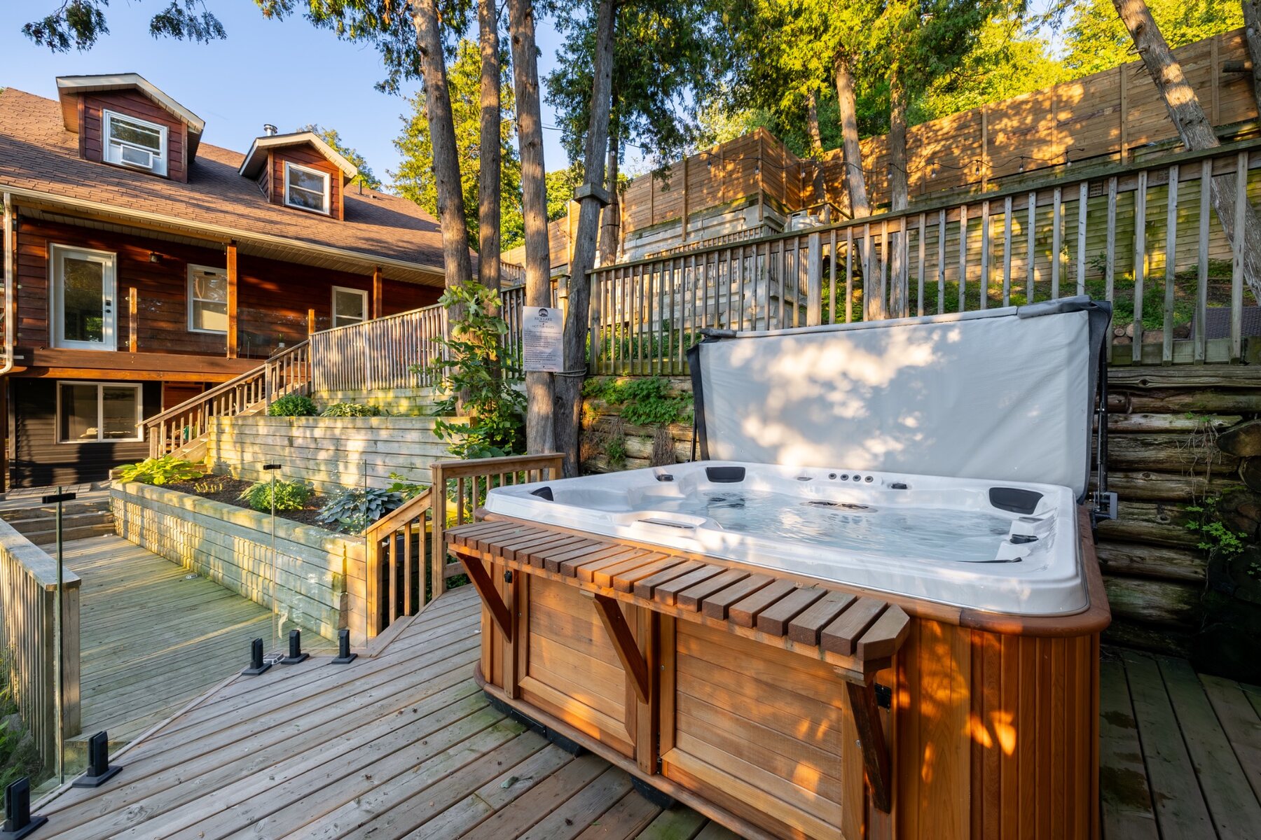 Private hot tub on a wooded deck beside the cottage